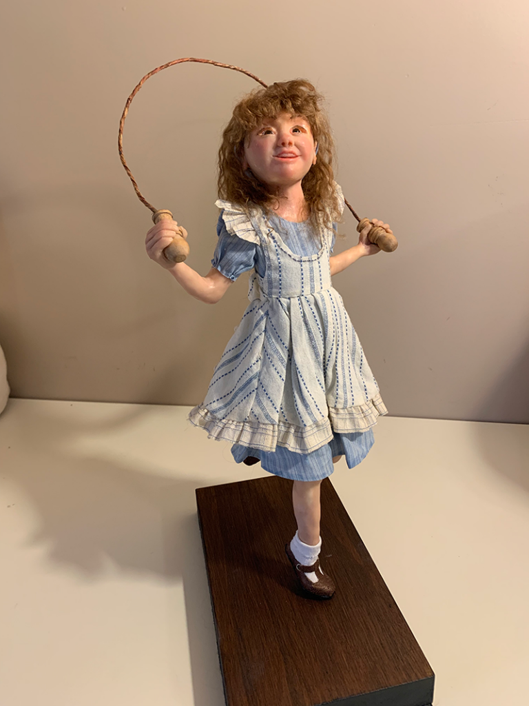 A handmade doll of a white girl skipping jump rope.