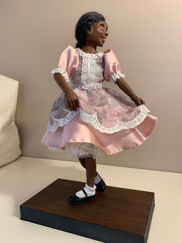 A handmade doll of a girl in a pink dress